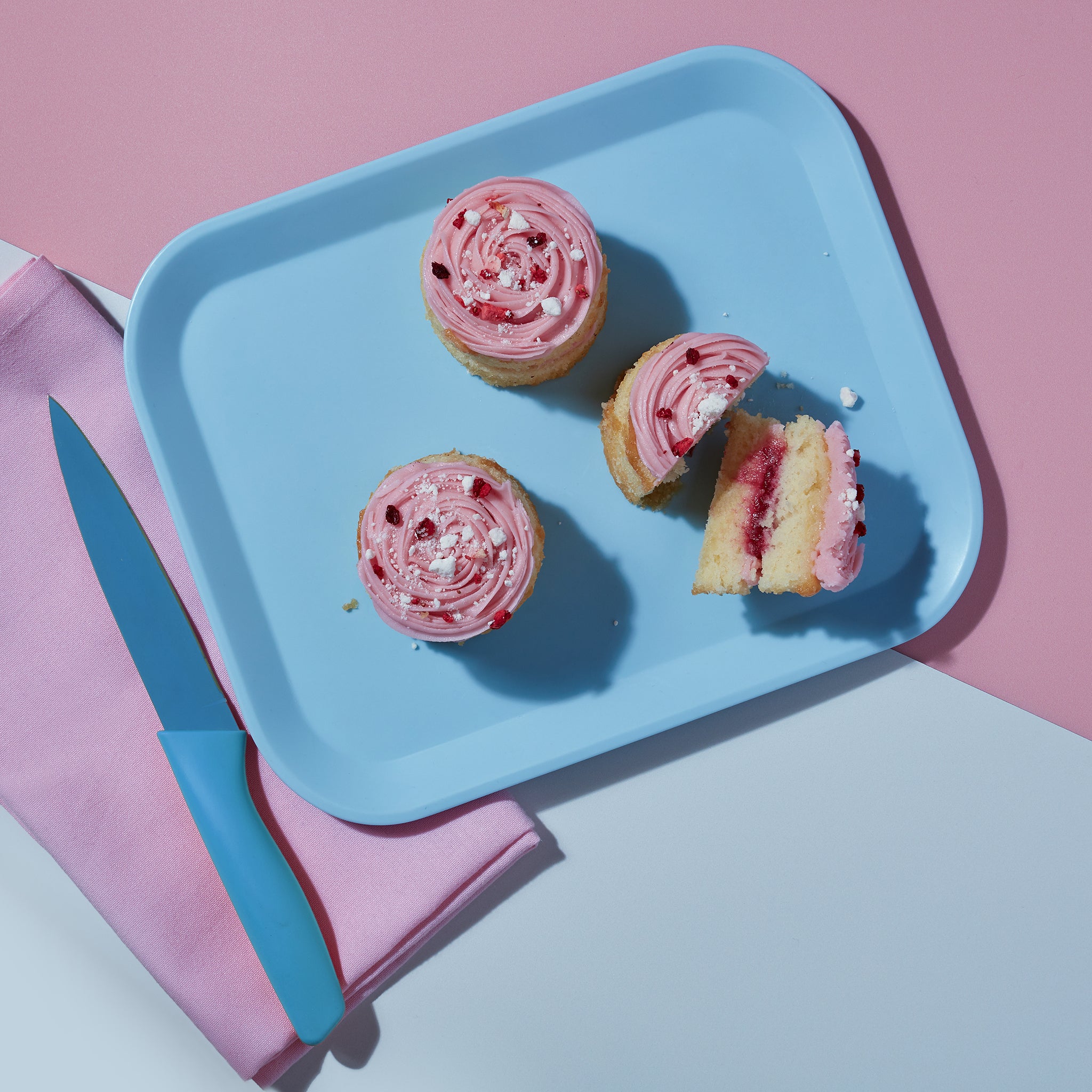 An overhead view of three Eaton Mess Mini Cakes from Cake Club on a blue plate