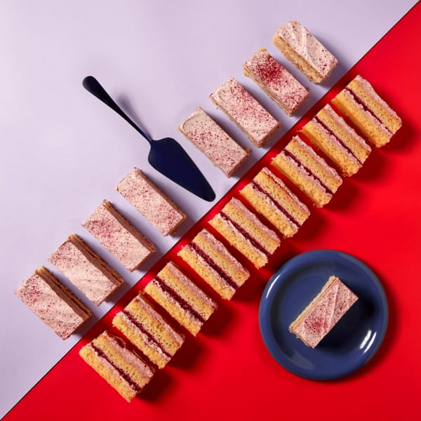 A full tray of Blackberry and Mascarpone Traycake on a lilac and red background.