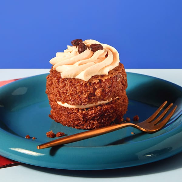 A single, untouched Little Latte cupcake from Cake Club sitting on a plate, waiting to be enjoyed!