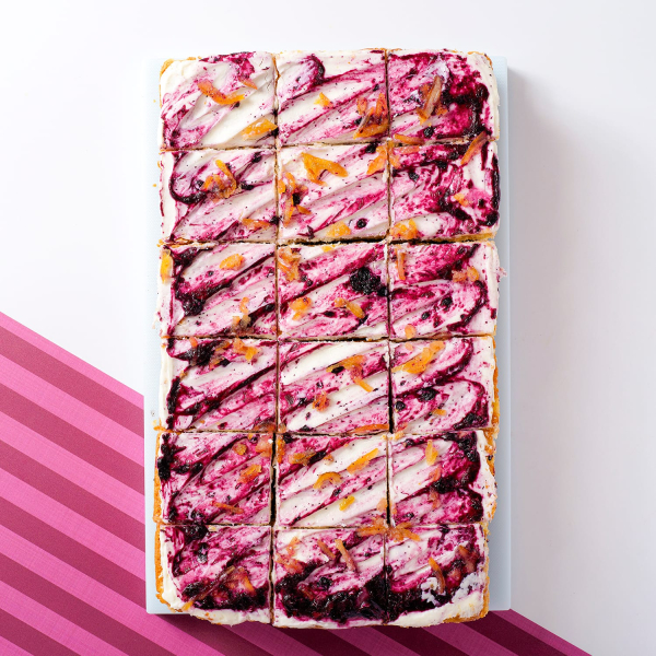 overhead image of Lemon Blueberry and Mascarpone Traycake with white and pink stripy background